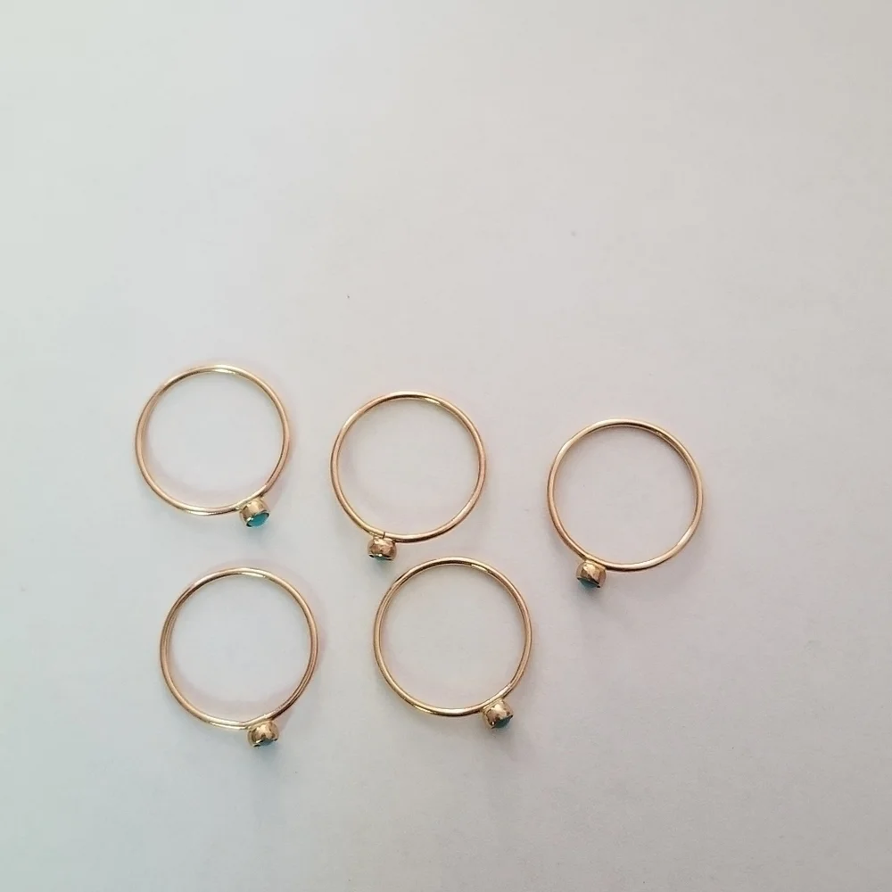 set of 5 gold tone stacking rings with small blue cabochon size 5.25